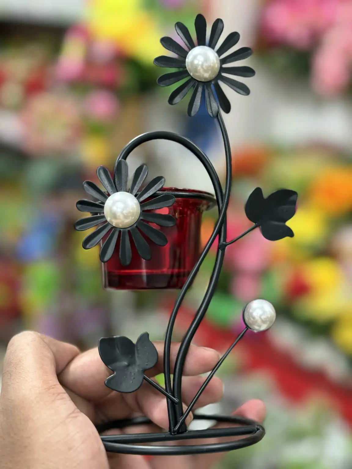 A metal candle holder with flower-shaped details