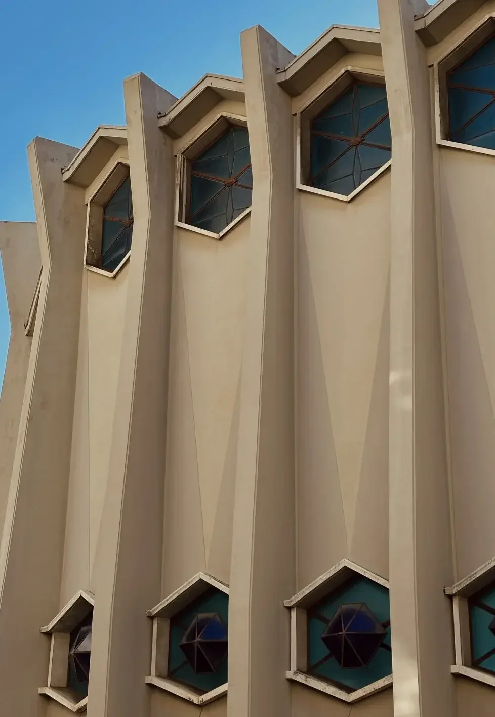 A quiet geometric facade in warm stone